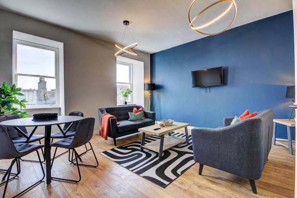 欧文The Irvine - Coorie Doon Apartments的客厅拥有蓝色的墙壁和桌椅