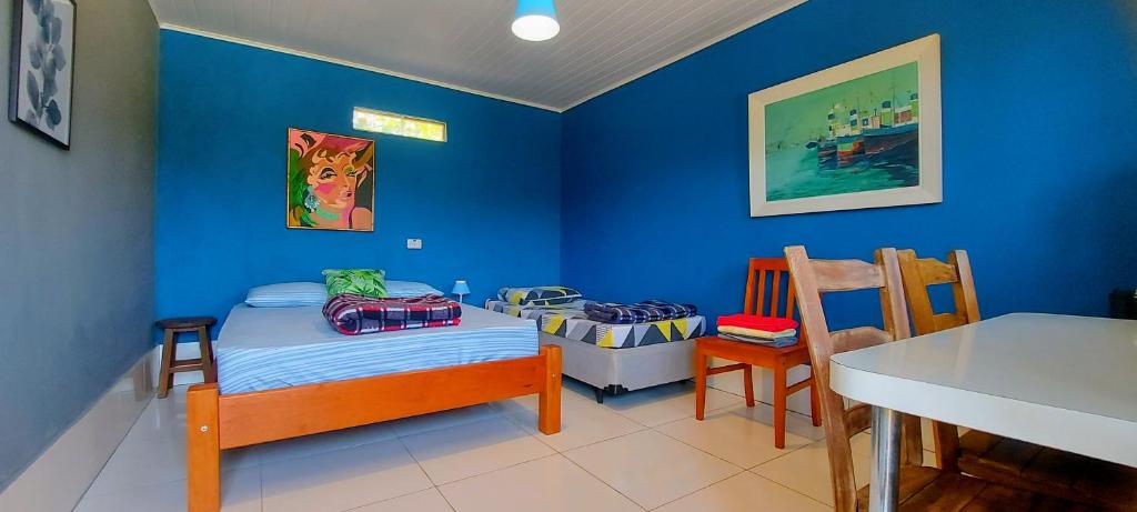 圣罗克Rancho Acácia São Roque的蓝色的客房配有一张小床和一张桌子