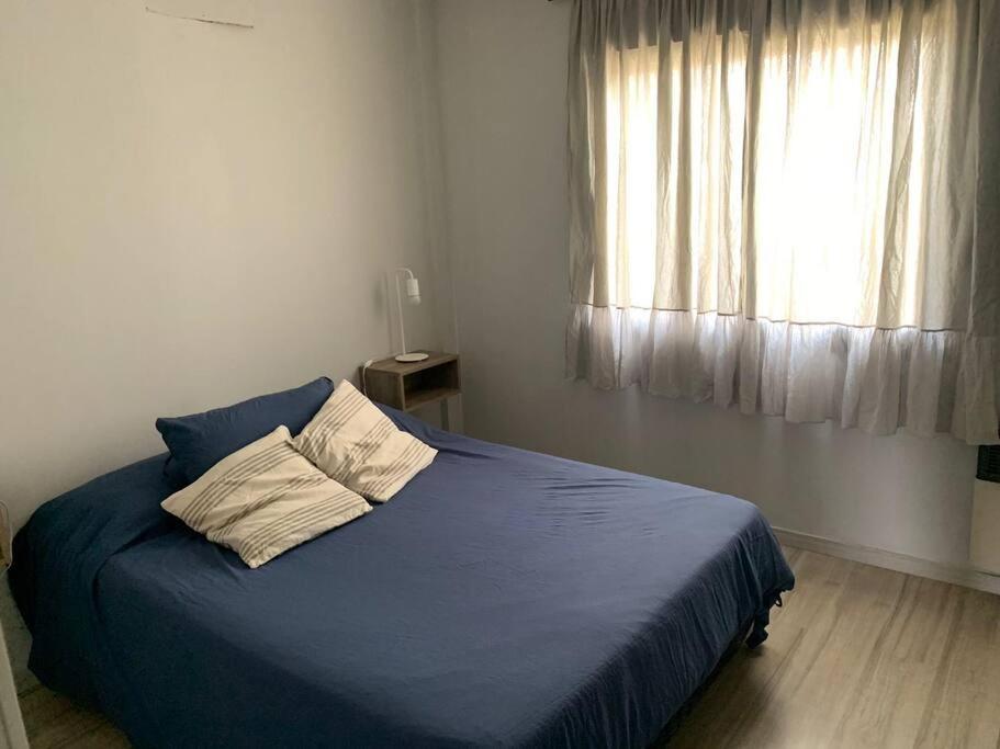 圣尼古拉斯Dpto. Rivadavia con vista al río的一间卧室设有蓝色的床和窗户。