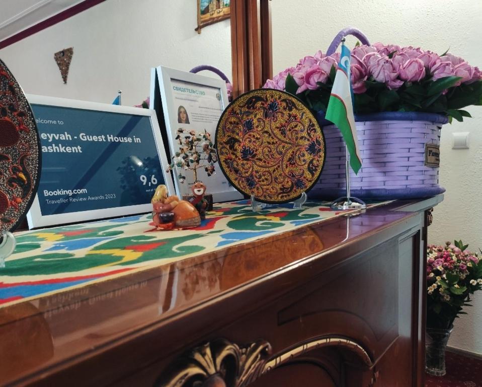 塔什干Heyvah - Guest House in Tashkent的一张桌子上放着篮子和鲜花