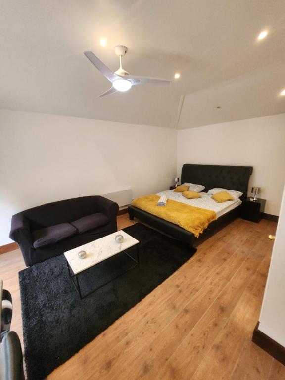 贝克斯利黑思Cosy Studio Flat的一间卧室配有一张床和一张沙发