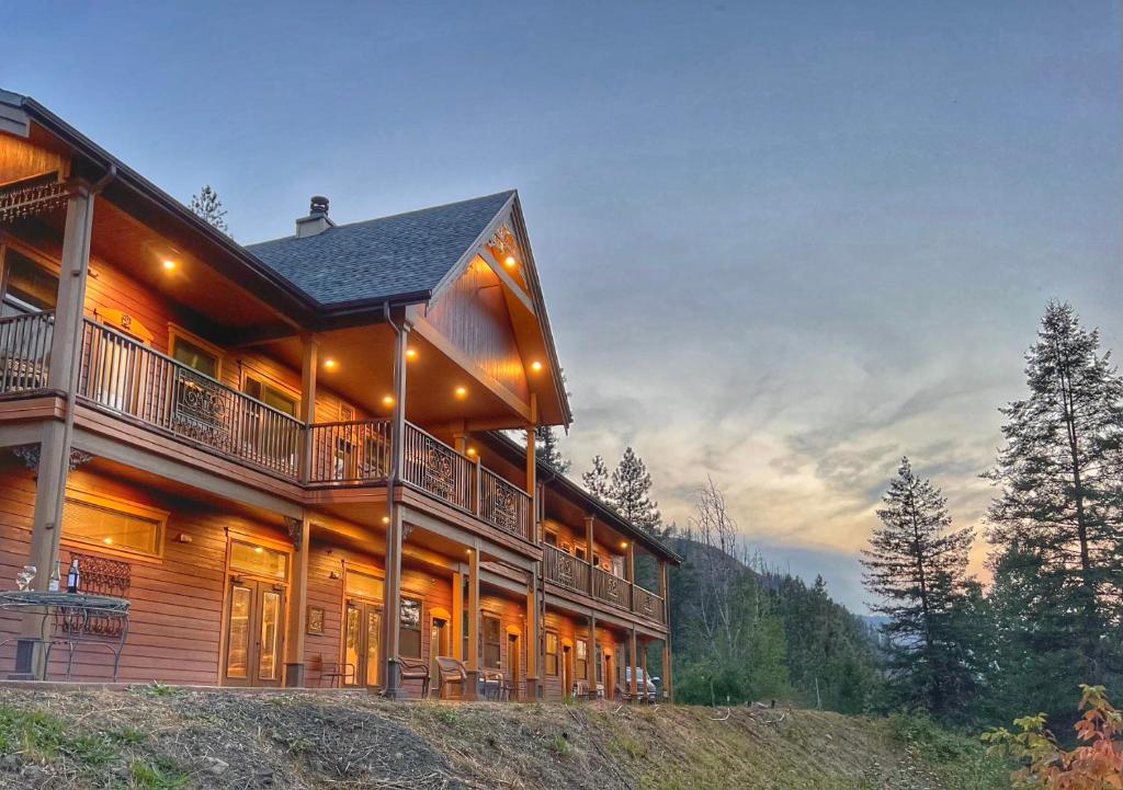 KamiahHearthstone Elegant Lodge的一座位于山丘上的大型木屋,设有阳台