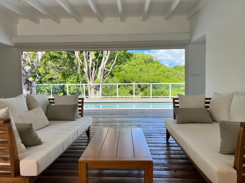 哥西尔Bienvenue à la Villa Ifè的带沙发和桌子的客厅以及游泳池。