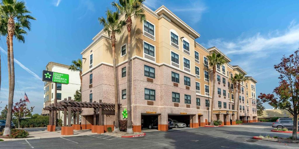 贝尔蒙Extended Stay America Premier Suites - San Francisco - Belmont的一条街道前方有棕榈树的大建筑
