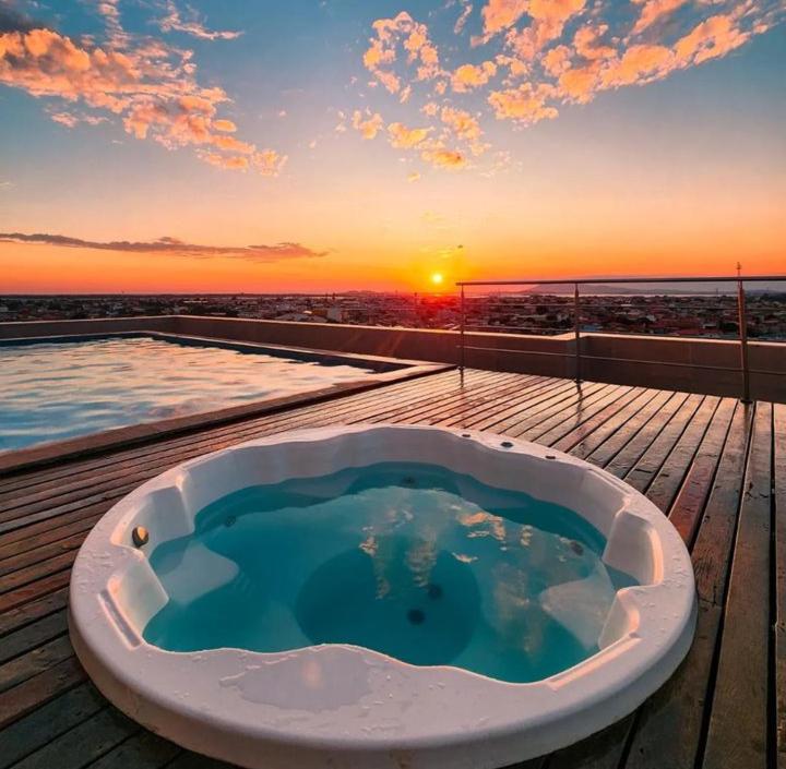 卡波布里奥帕拉迪索公司酒店的甲板上的浴缸,背面是日落