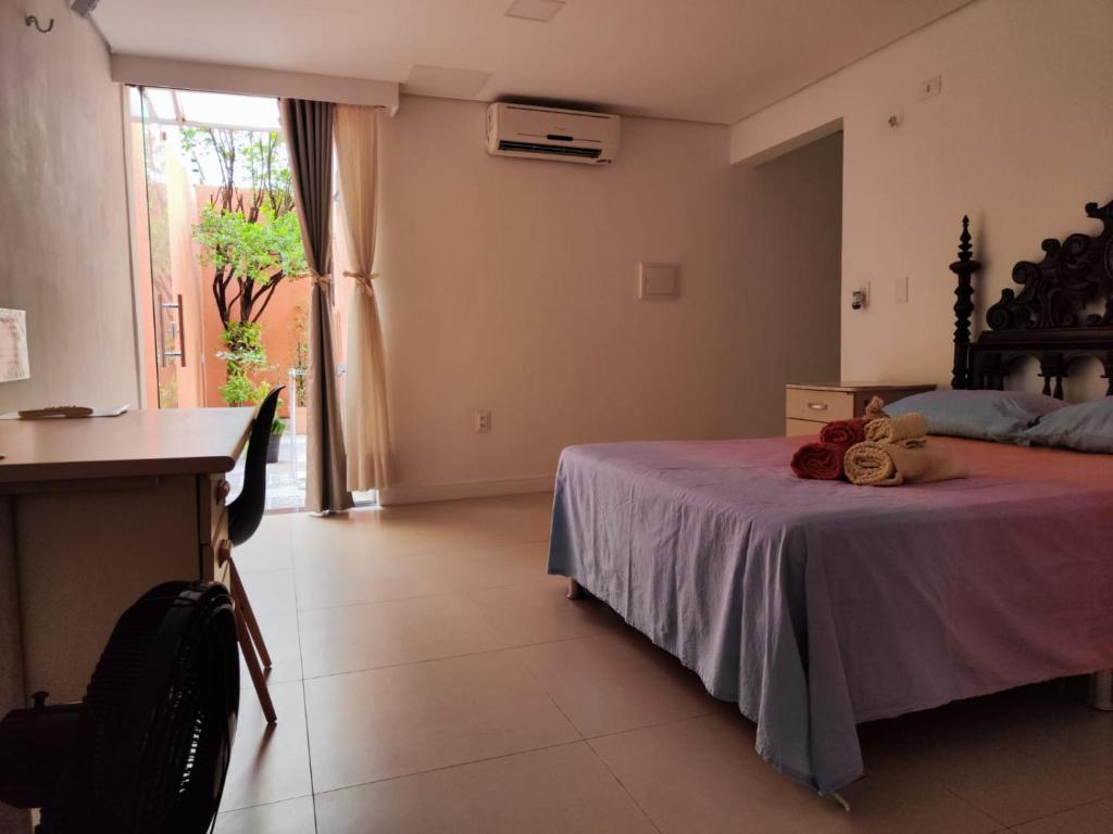 福塔莱萨Casa Sagrada 282的一间卧室配有一张床、一张书桌和一个窗户。