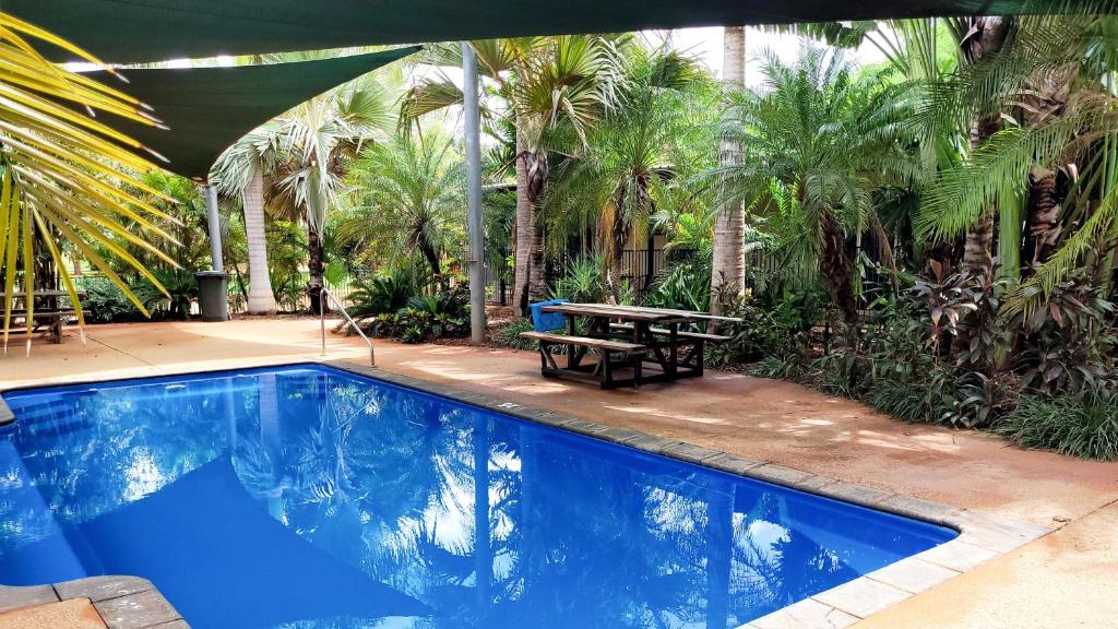 布鲁姆雄鹿平原汽车旅馆的一个带野餐桌和棕榈树的游泳池