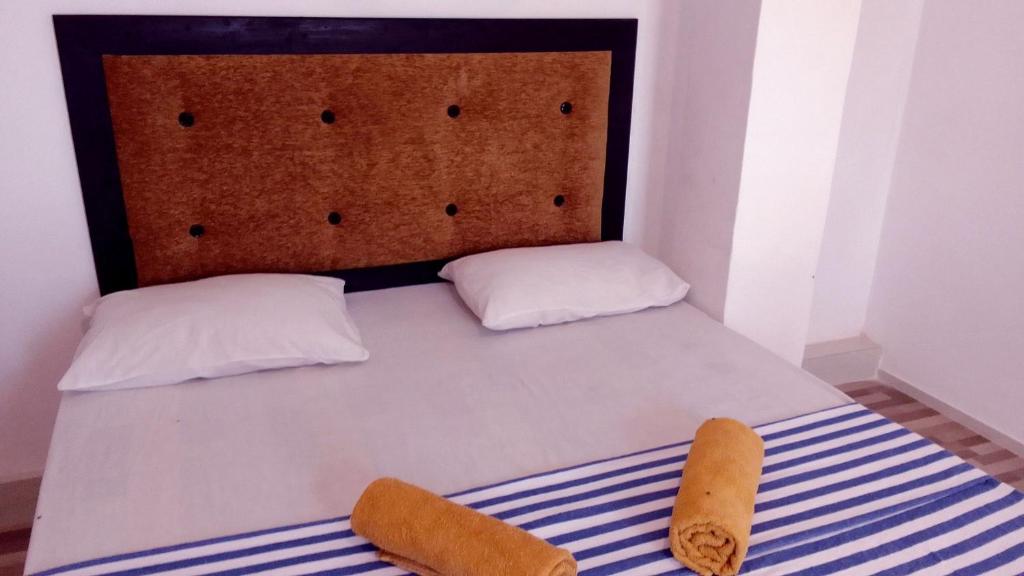 达瓦拉维Big House Udawalawe的一张带两个枕头和床头板的床