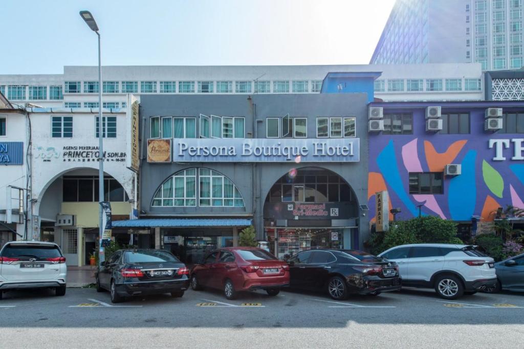 马六甲Persona Boutique Hotel的停车场,停车场停在大楼前