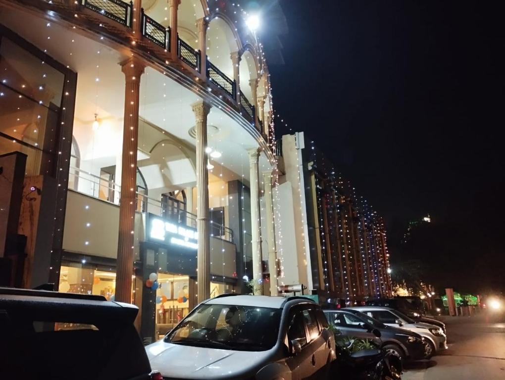 阿格拉Hotel Tara Palace by Goyal Hoteliers的夜间停在大楼前的汽车