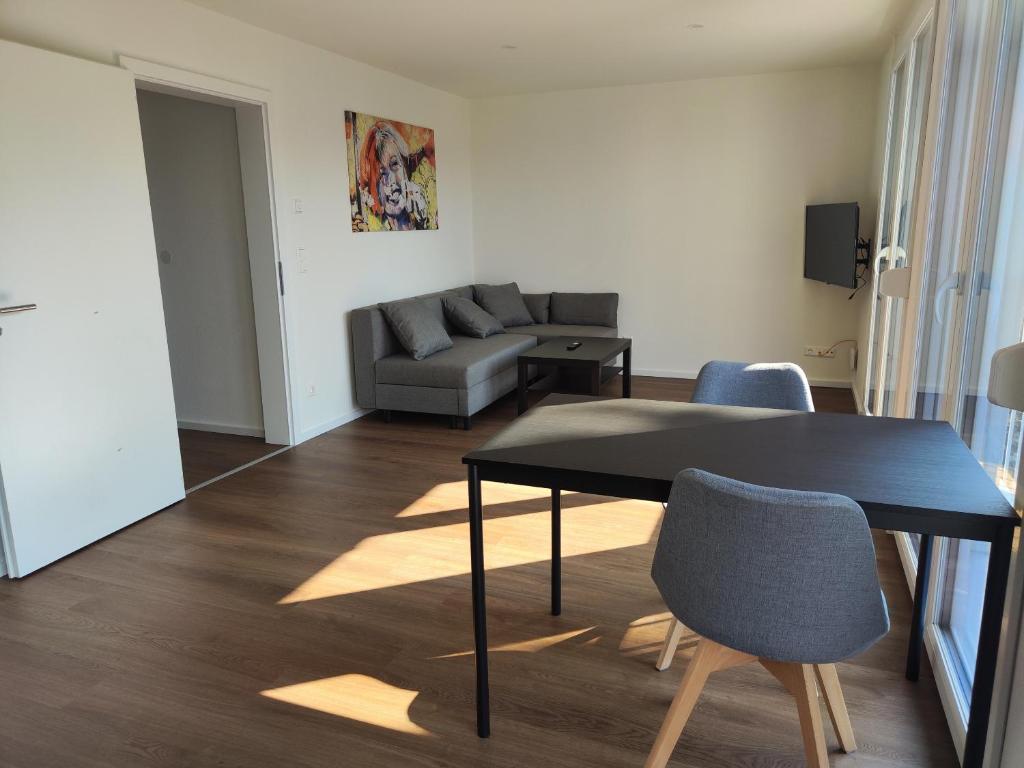 普福尔茨海姆Apartmenthaus Pforzheim的客厅配有桌子和沙发