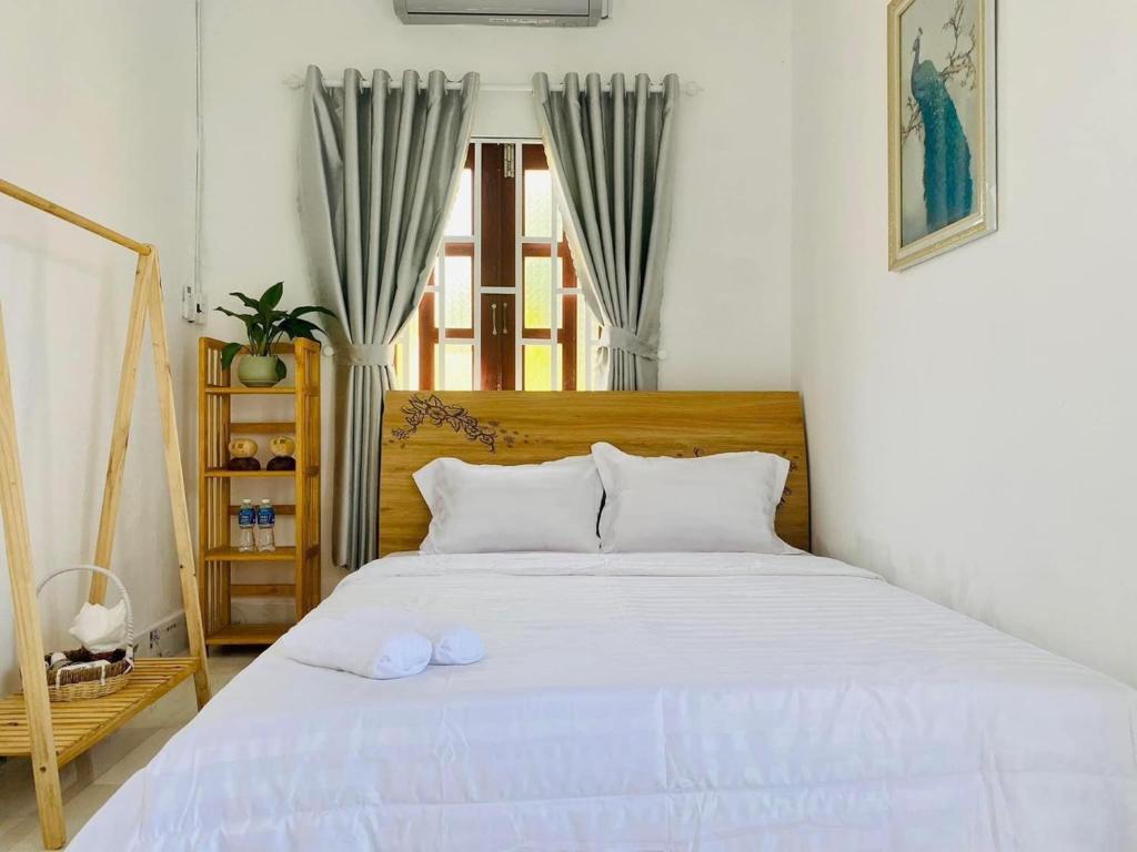 Ninh HảiNại Home Venuestay的一间卧室配有一张带白色床单的床和一扇窗户。