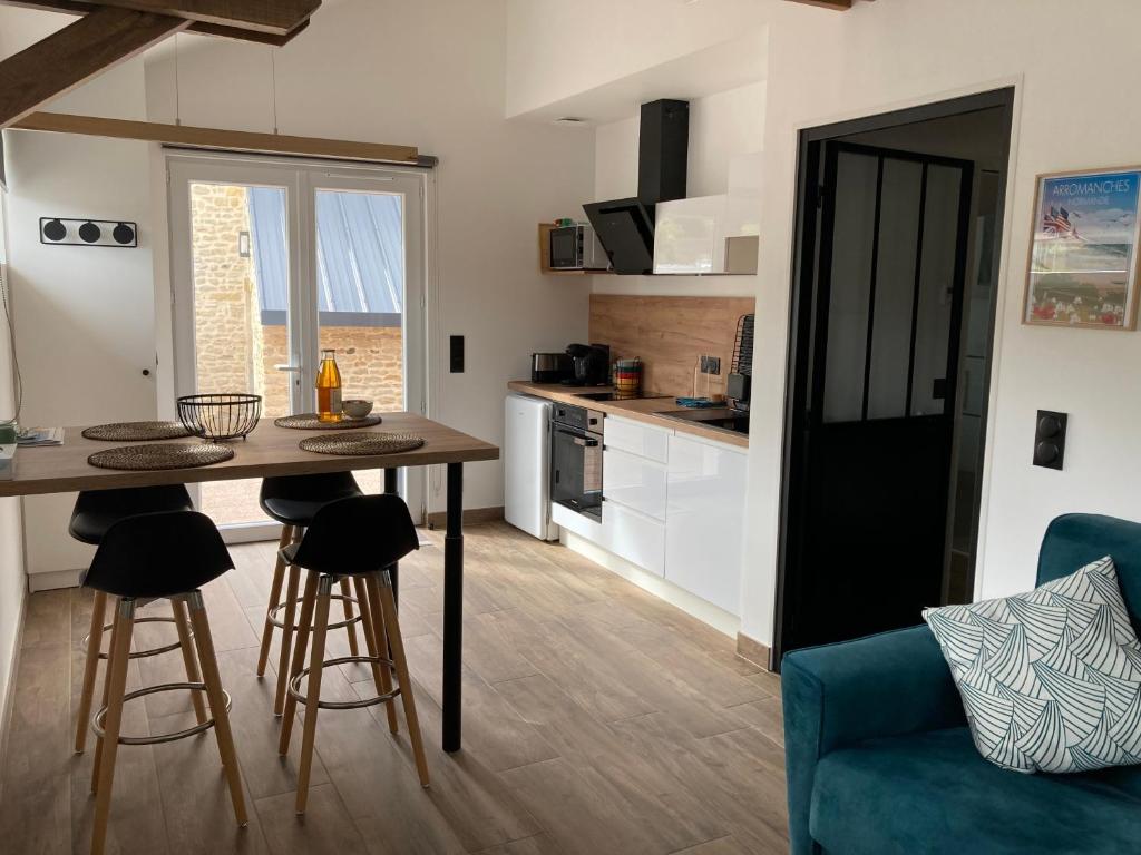 阿罗芒什莱班L’Atelier的厨房以及带桌椅的起居室。