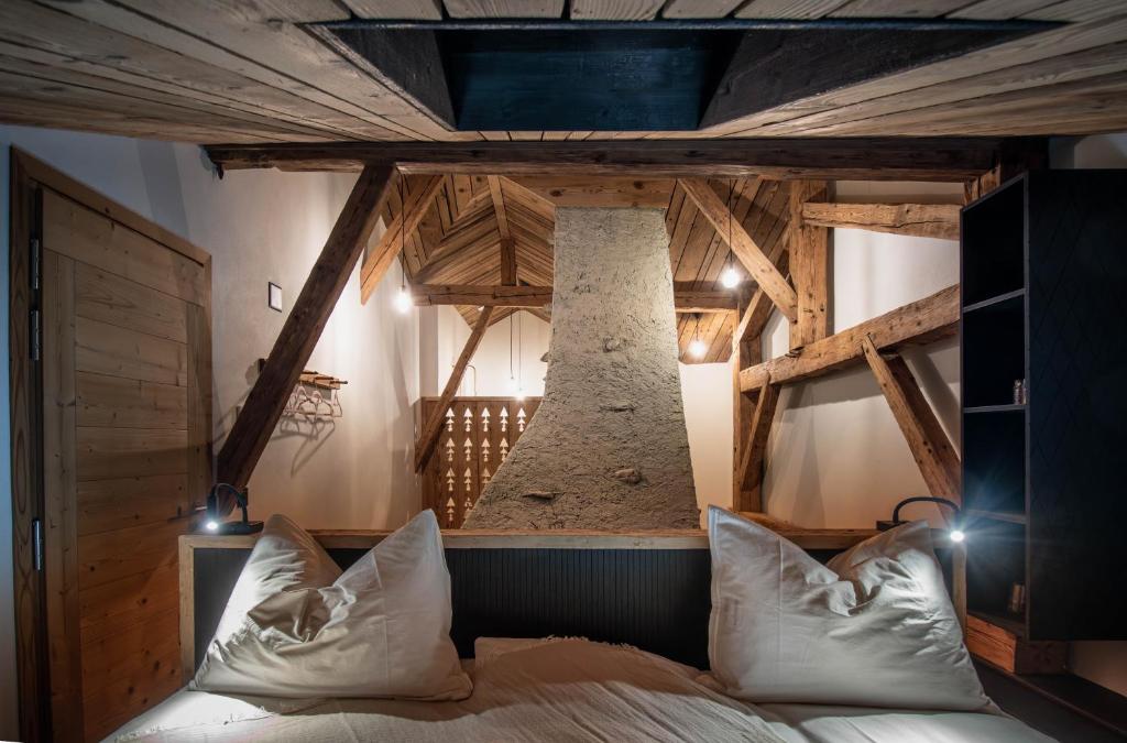 La SagneHôtel-Restaurant Le Cochon Rose的一间带一张床的卧室,位于带木制天花板的房间内