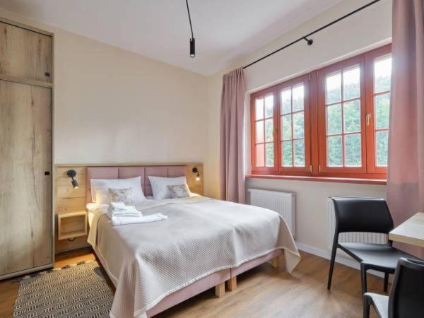 米迪格兹Villa Winkler的一间卧室配有一张床、两把椅子和窗户