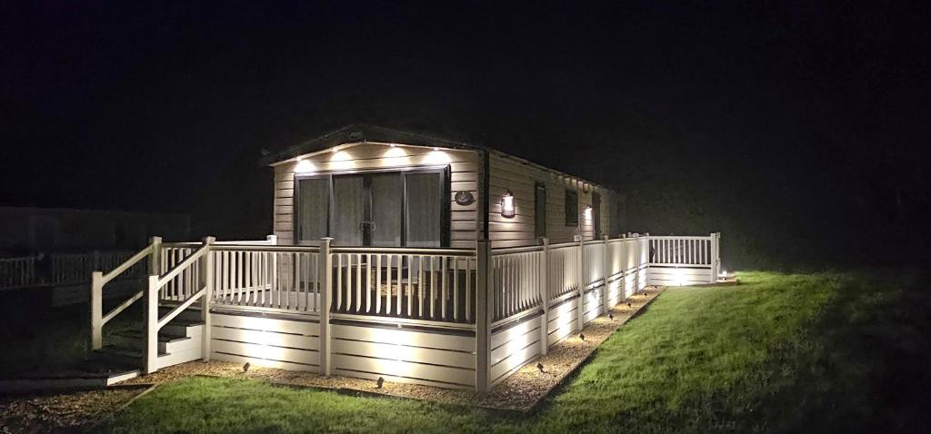 圣奥斯特尔Hot Tub Lodge Cornwall - Meadow Lakes Holiday Park的夜间有灯的小屋