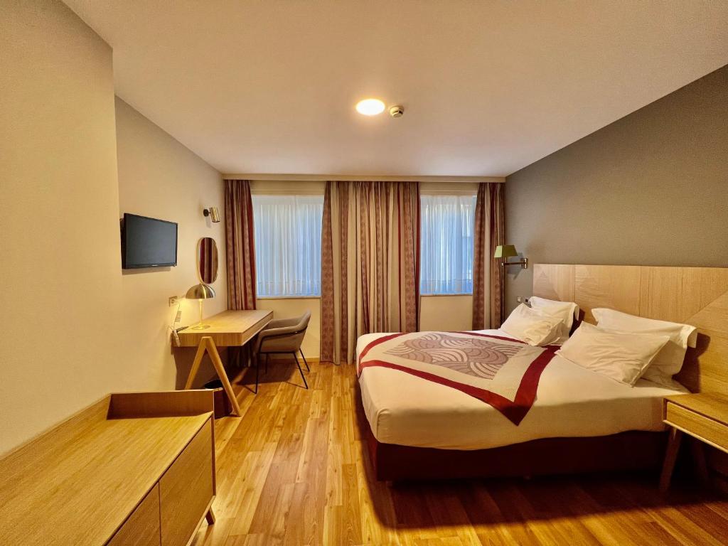 布鲁塞尔Bedford Hotel & Congress Centre Brussels的配有一张床和一张书桌的酒店客房