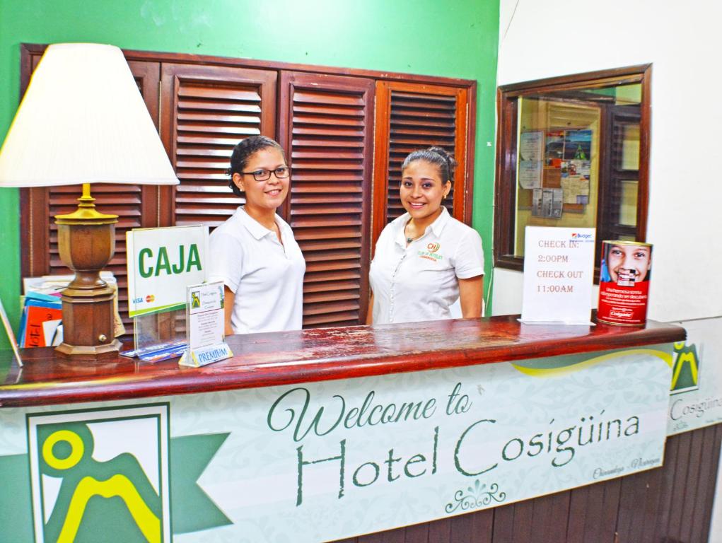 奇南德加Hotel Plaza Cosiguina的两名妇女站在旅馆接待台后面