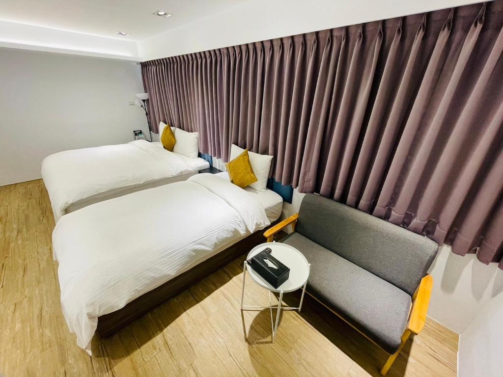 台北森浩文旅的酒店客房,设有两张床和一张沙发