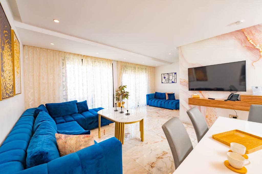 卡萨布兰卡Family Aparthotel的客厅配有蓝色的沙发和电视