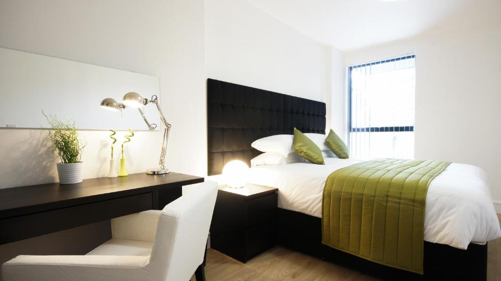 伦敦安道​​尔公寓 的一间卧室配有一张床和一张桌子及椅子