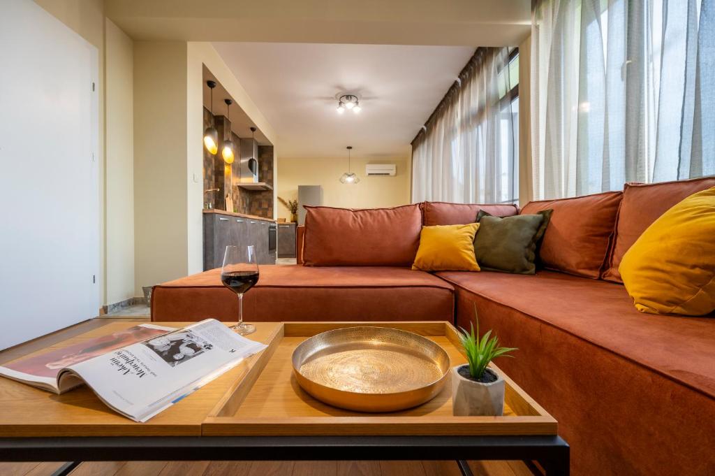 普罗夫迪夫Three Lilies Apartments的客厅配有棕色沙发和桌子