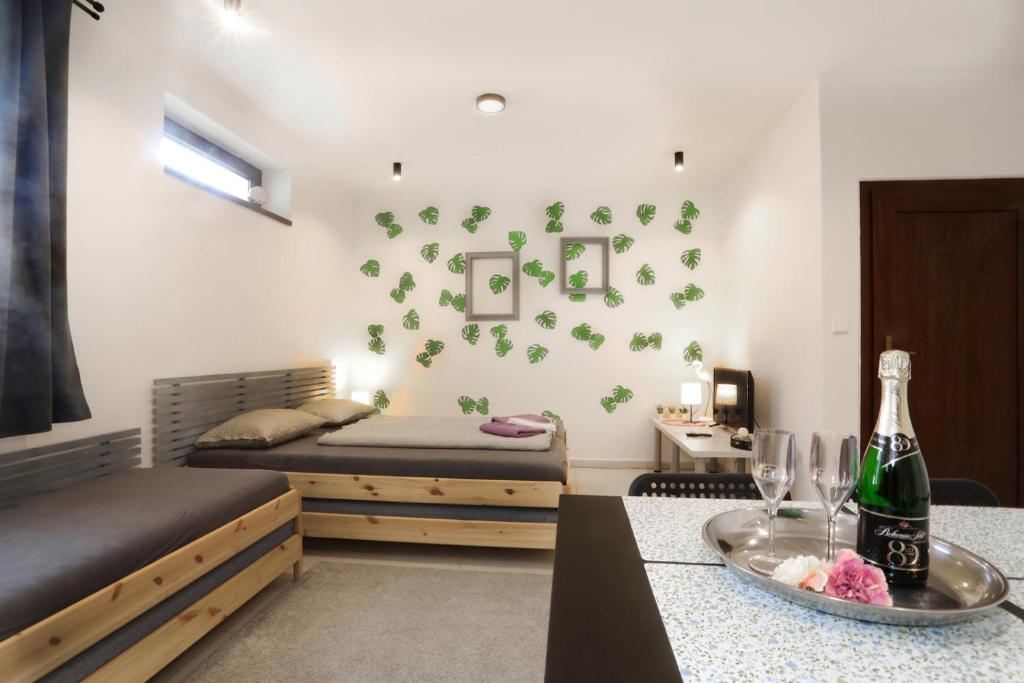 摩拉瓦河畔韦塞利Apartmán Wellness Veselí的一间卧室设有两张床和一张桌子,并提供一瓶葡萄酒