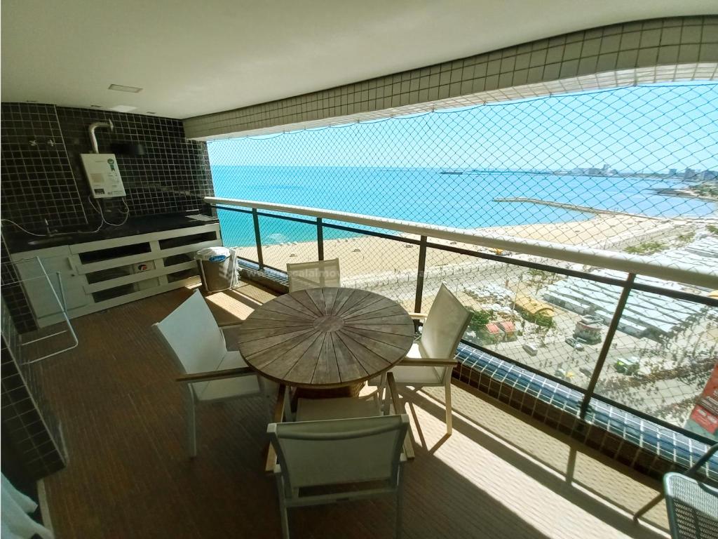 福塔莱萨Escala Landscape Beira Mar的阳台配有桌椅,享有海滩美景。