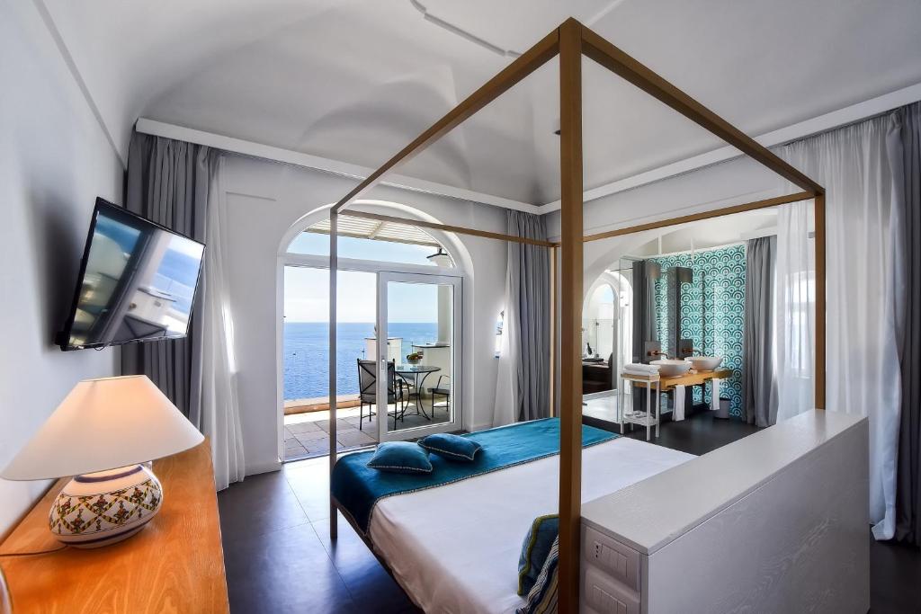 波西塔诺蒙特马雷酒店的一间卧室设有一张天蓬床,享有海景