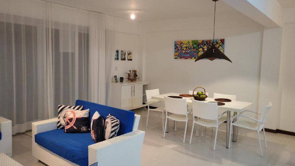 Entre RiosApartamento Particular de 03 suítes, Resort Treebies, Praia de Subauma - Ba的客厅配有桌子和蓝色沙发