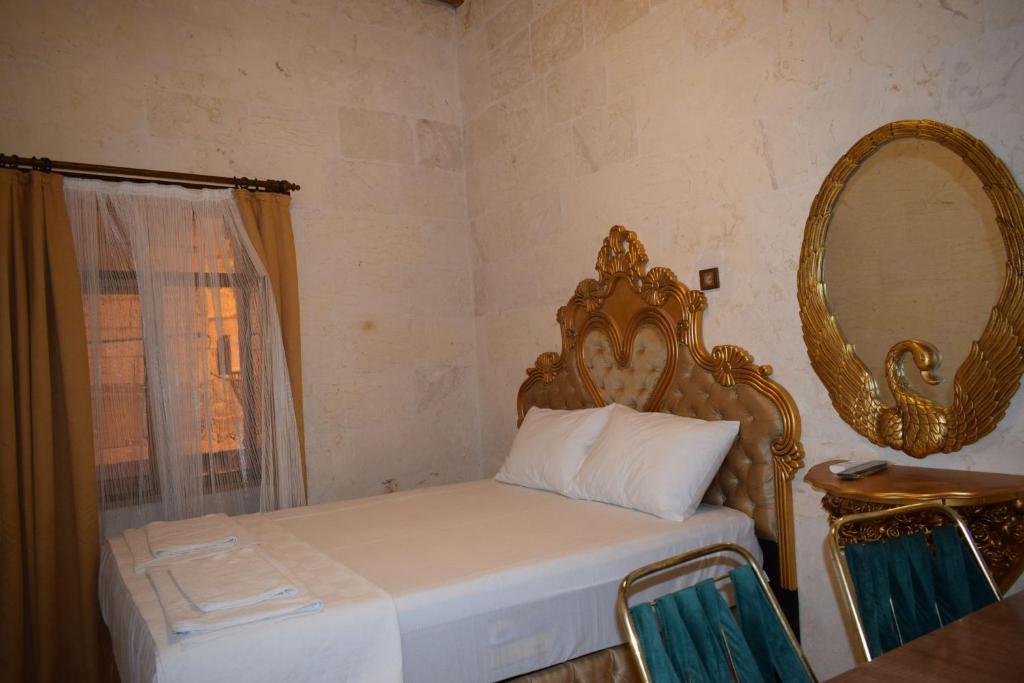 尚勒乌尔法Hasan Paşa Konuk Evi的卧室配有一张壁挂镜子的床