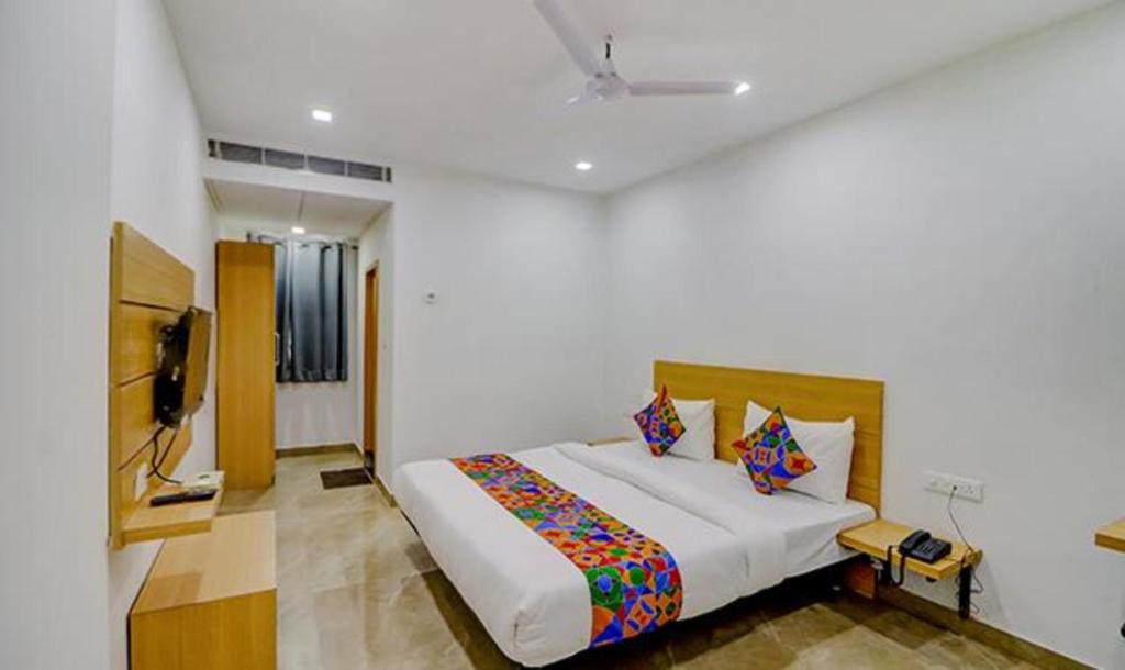 瓦拉纳西FabHotel Premium Kashi的一间卧室配有一张床和一台电视