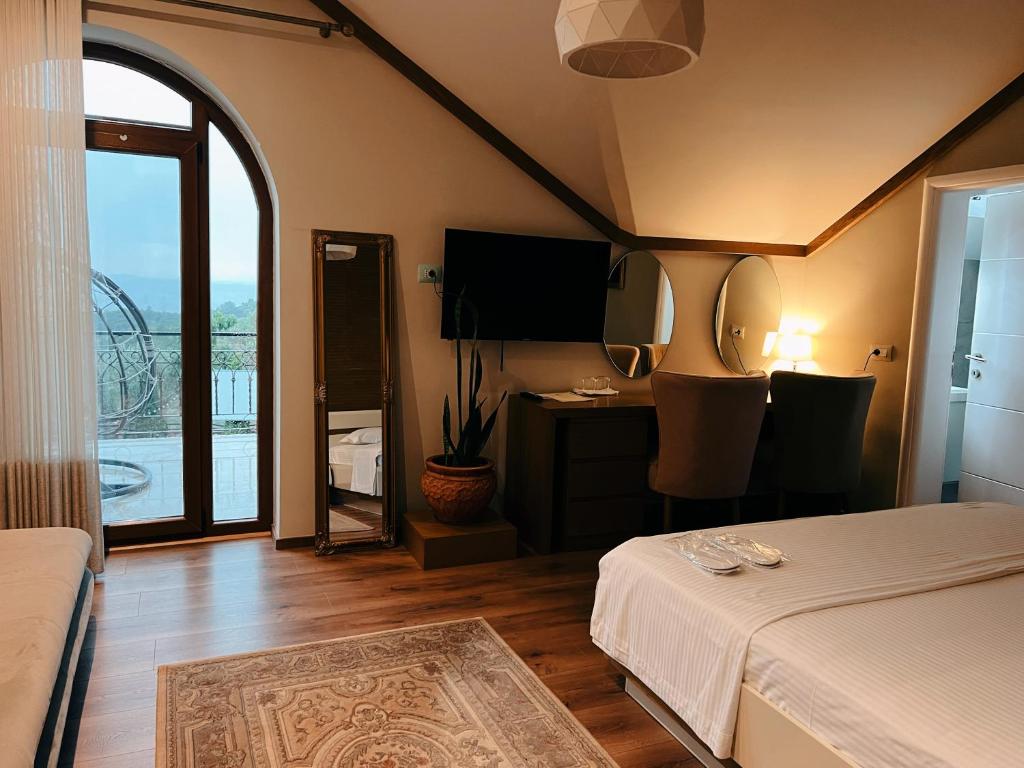 地拉那Chateau Fasel的一间卧室配有一张床和一张书桌及电视