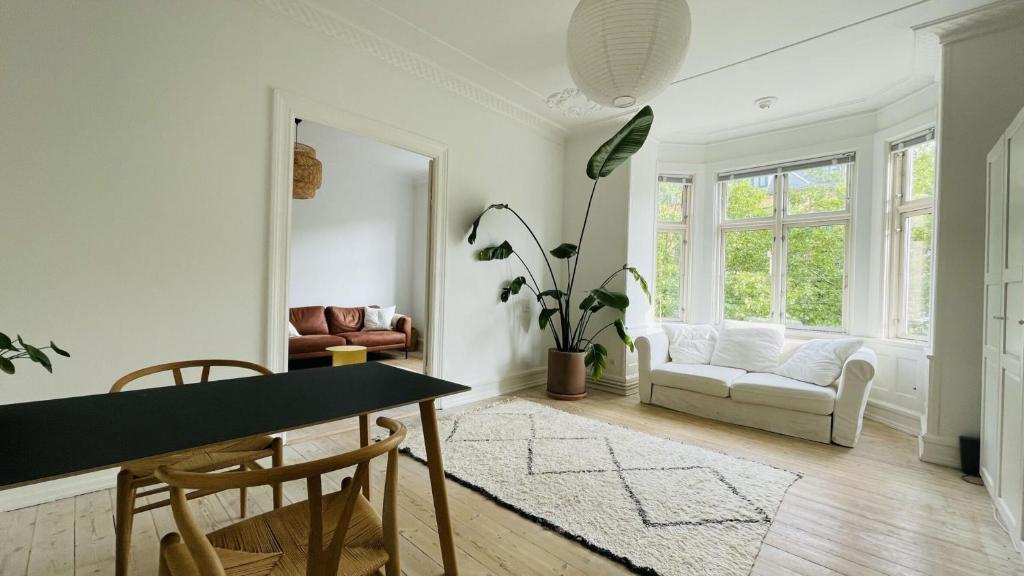 哥本哈根ApartmentInCopenhagen Apartment 1563的客厅配有桌椅和沙发