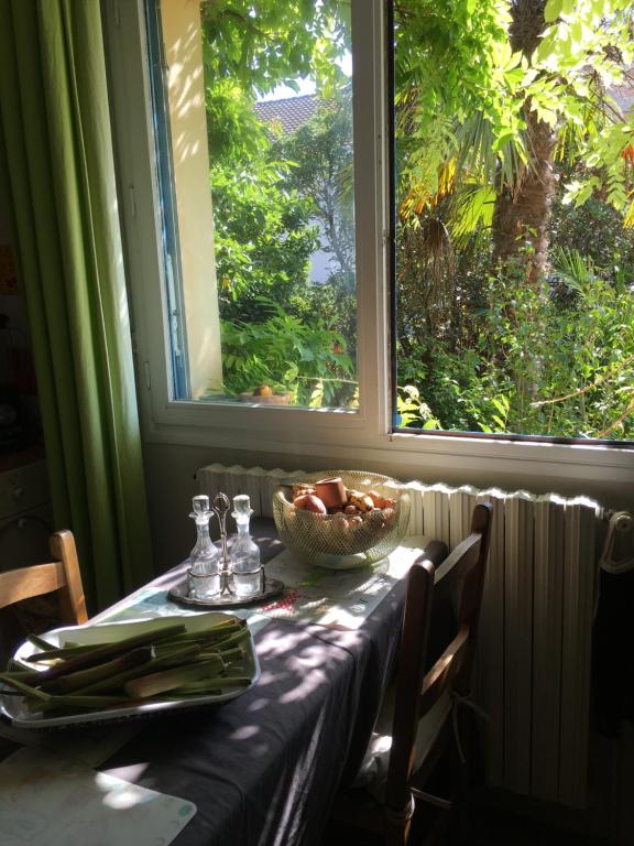 蒙德维尔Chambre spacieuse et lumineuse的一张桌子,上面放着一碗水果,还有一个窗口