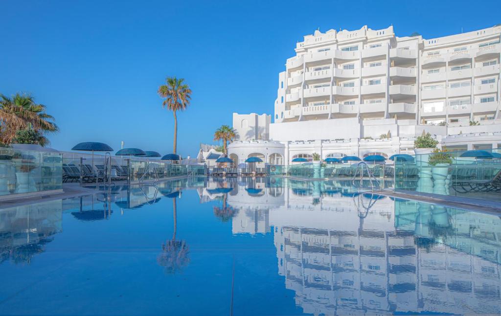 圣米格尔德阿沃纳圣巴巴拉高尔夫及海洋俱乐部钻石度假酒店的一座建筑前有水池的酒店