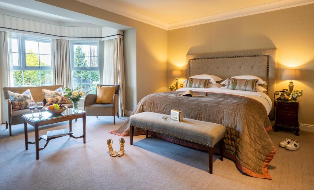 特拉利Ballygarry Estate Hotel & Spa的一间卧室配有一张床、一把椅子和一张桌子