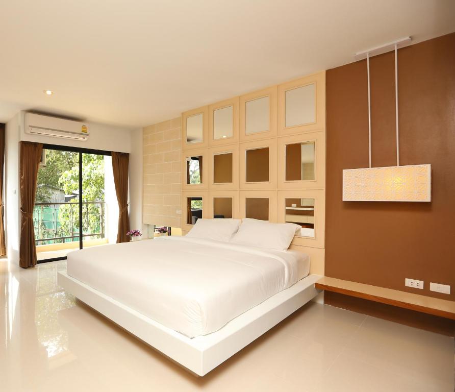 普吉镇纳卡住处酒店的窗户客房内的一张大白色床