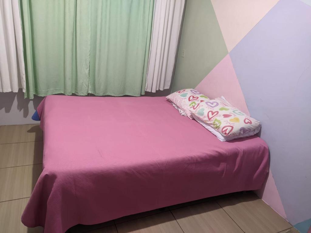 布卢梅瑙CASA PARA OKTOBERFEST 12 PESSOAS.的一张带粉红色床单和枕头的小床
