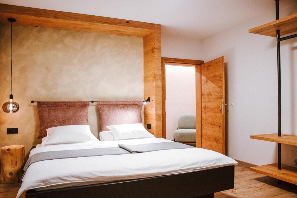 里约比安科Hotel Schönberg B&B的一间卧室配有一张大床和木制床头板