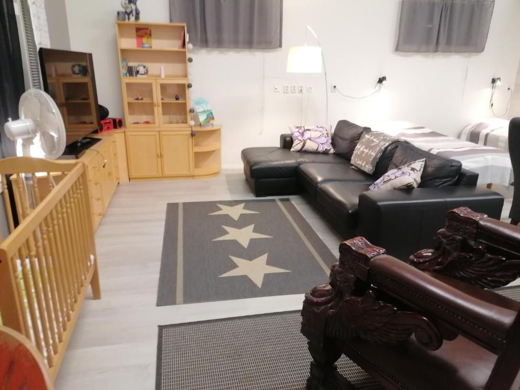 拉赫Majoituspalvelu Nurmi Apartments Välitie的客厅配有黑色真皮沙发和星星,位于地板上