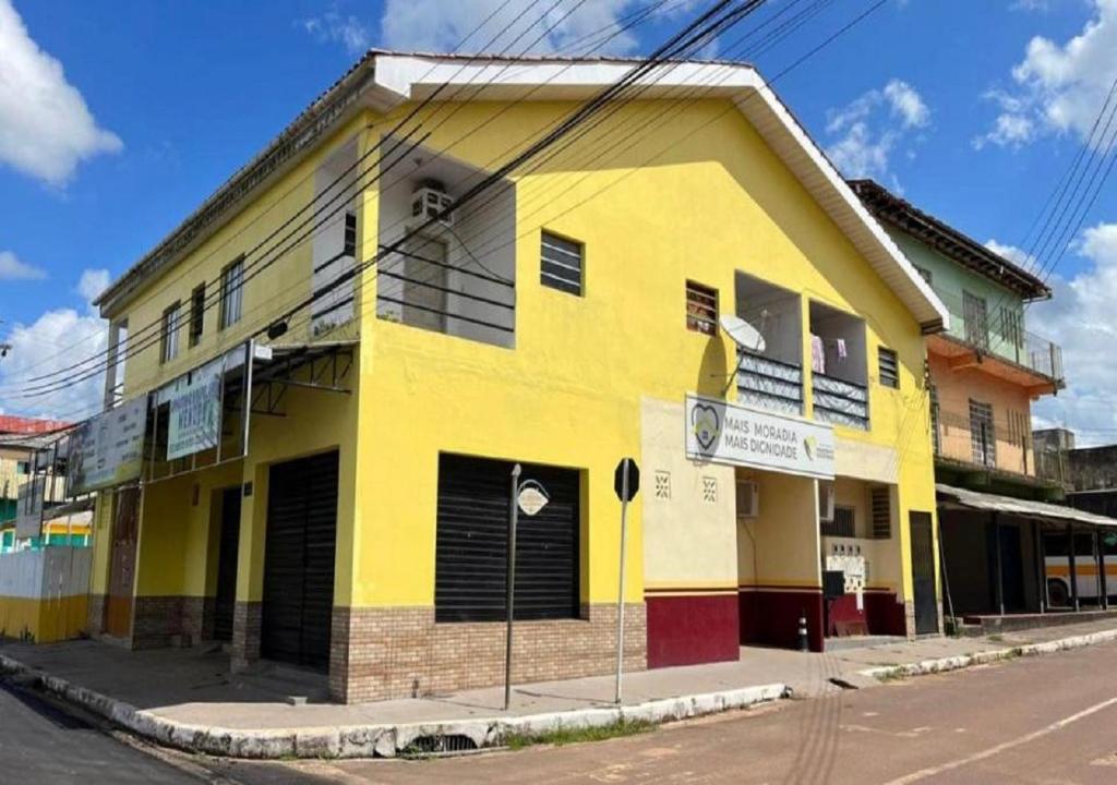 菲格雷多总统镇Residencial Margarida APART 5的街道拐角处的黄色建筑