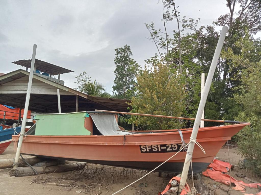 Kampong PandanThe BoatBnB的坐在房子一边的船