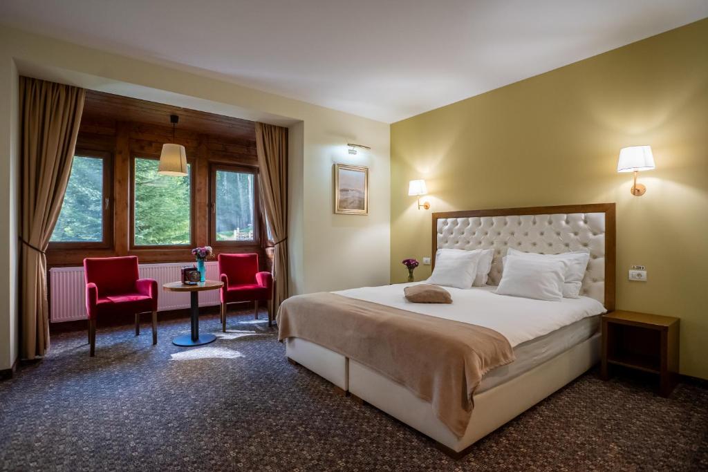 锡纳亚佳作别墅的酒店客房带一张床、一张桌子和椅子