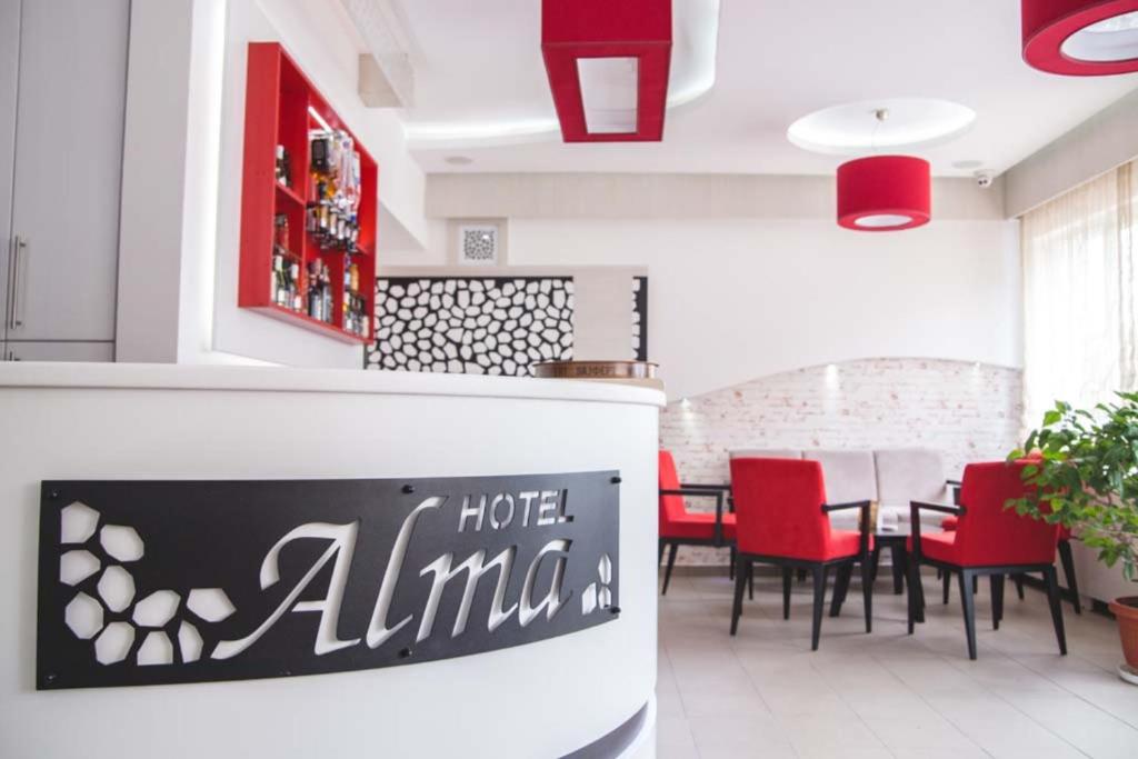 皮罗特Garni hotel Alma的一间带桌子和红色椅子的用餐室