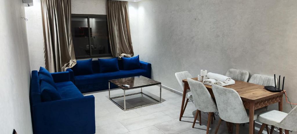丹吉尔Les Belles Appartements Family Only的一间配备有蓝色椅子和桌子的用餐室