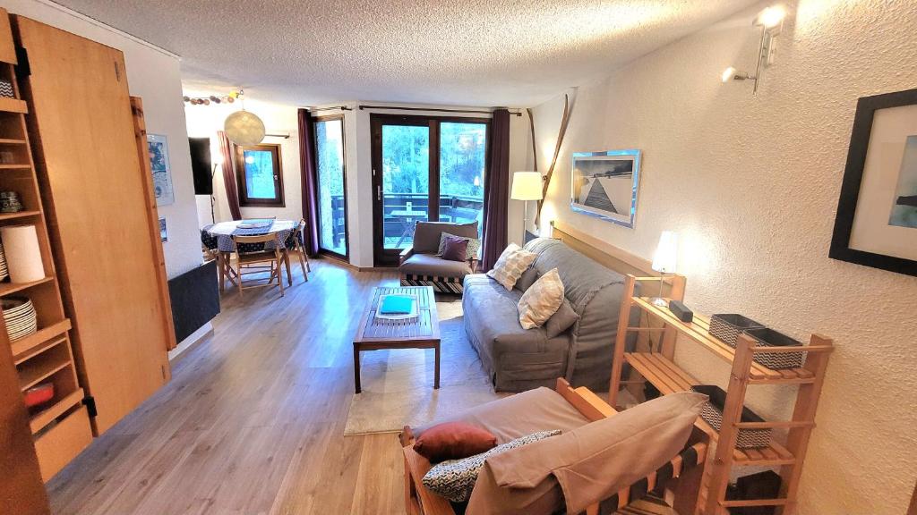 莱索尔Le Lodge des marmottes - Calme, cosy, vue nature的客厅配有沙发和桌子