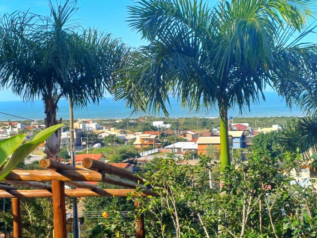 加罗帕巴Residencial Hibiscos - Vista Mar的两棵棕榈树的城市景观