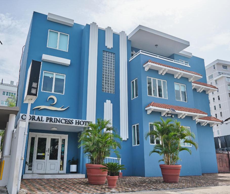 圣胡安珊瑚公主酒店的一座蓝色的建筑,前面有棕榈树