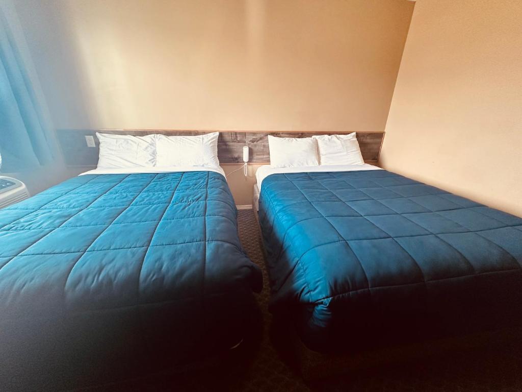 落基山庄Voyageur Motel的两张睡床彼此相邻,位于一个房间里